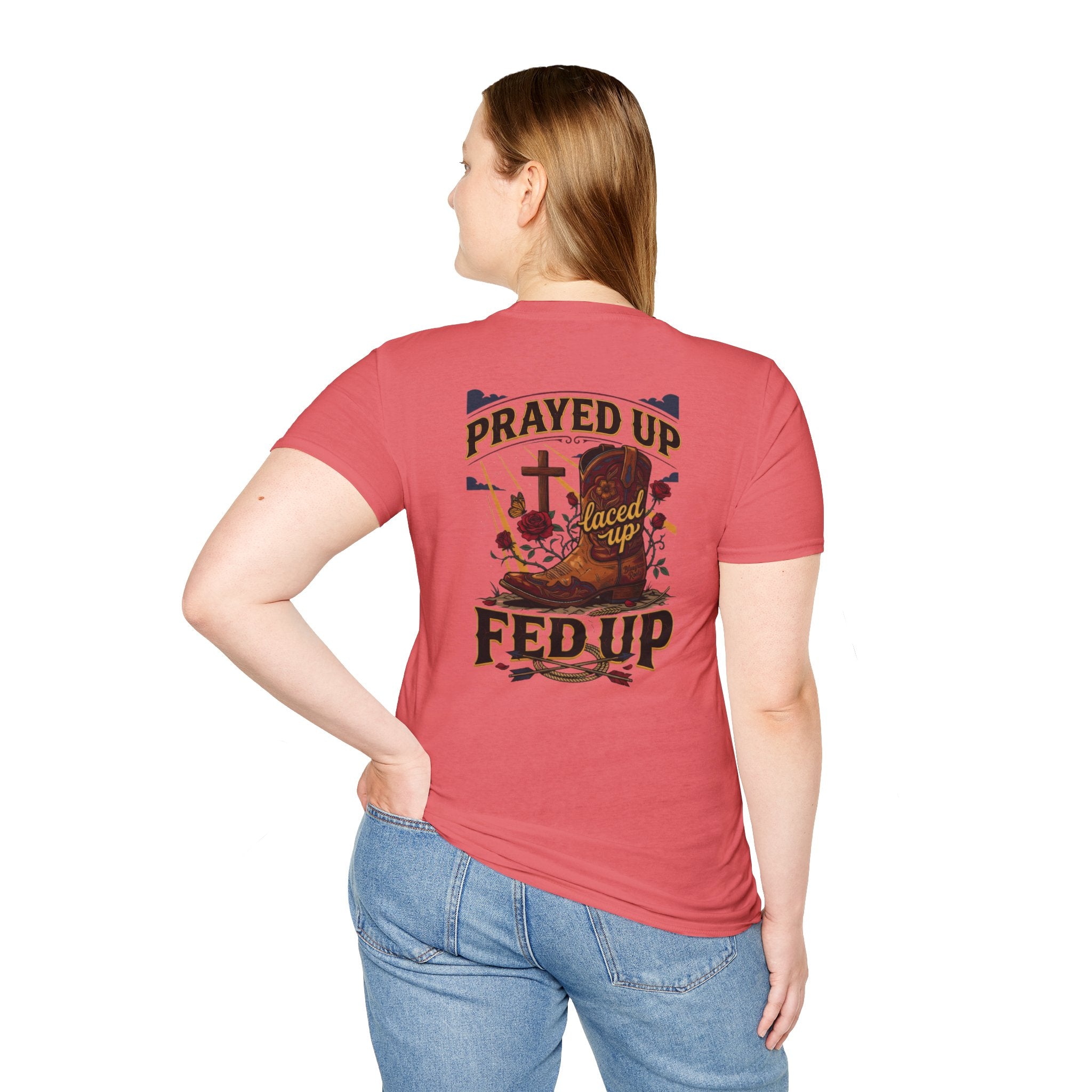 Woman wearing the Bluegrass Roots Prayed Up Laced Up Fed Up cowgirl boot tee in Coral Silk, standing pose