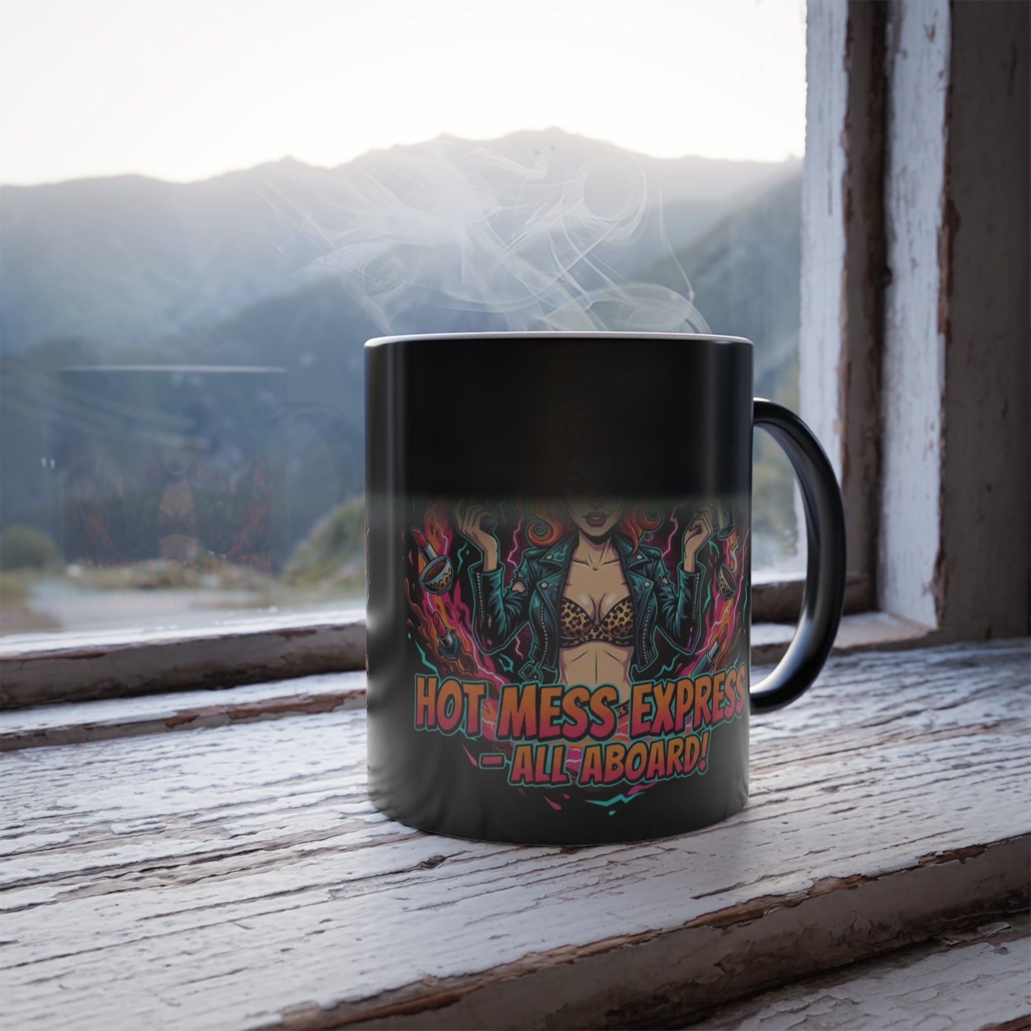 Black mug with colorful design and text on a wooden surface with a mountain view.