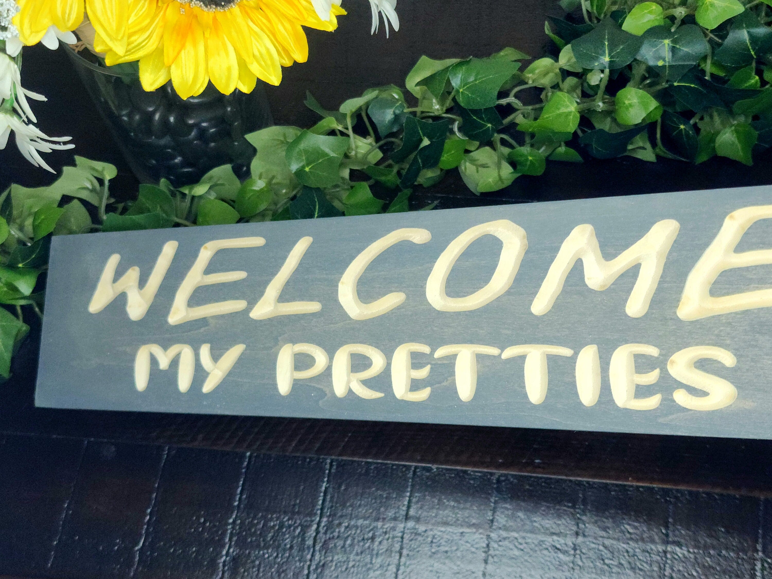 Decorative wooden Halloween sign featuring spooky lettering and rustic charm.
