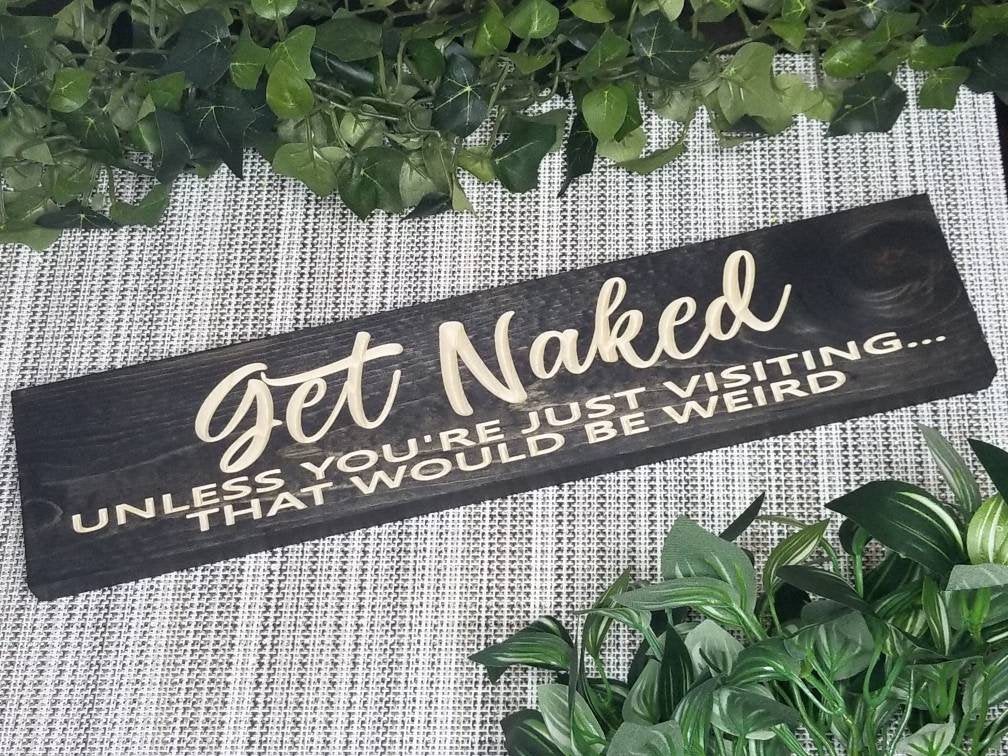Funny wooden bathroom sign reading "Get Naked Unless You're Just Visiting, That Would Be Weird."