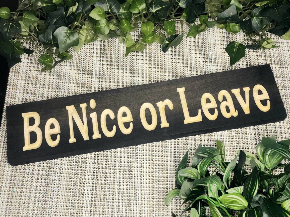 Rustic "Be Nice or Leave" wood sign displayed in a farmhouse-style entryway.