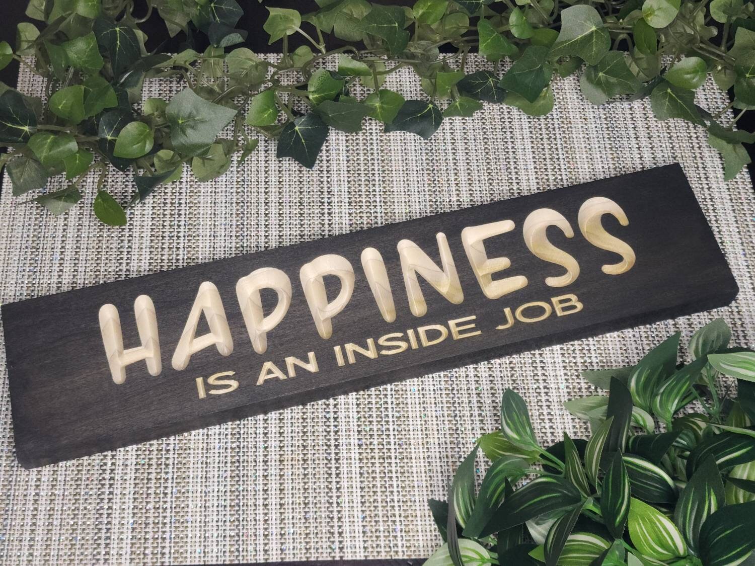 Rustic wooden "Happiness is an Inside Job" sign displayed in a cozy living room.
