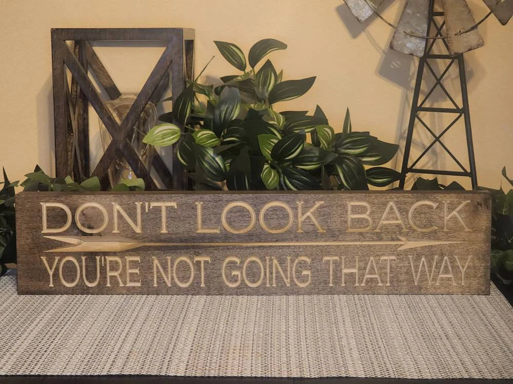 Rustic wooden sign with an inspirational quote styled in a cozy living room setting.