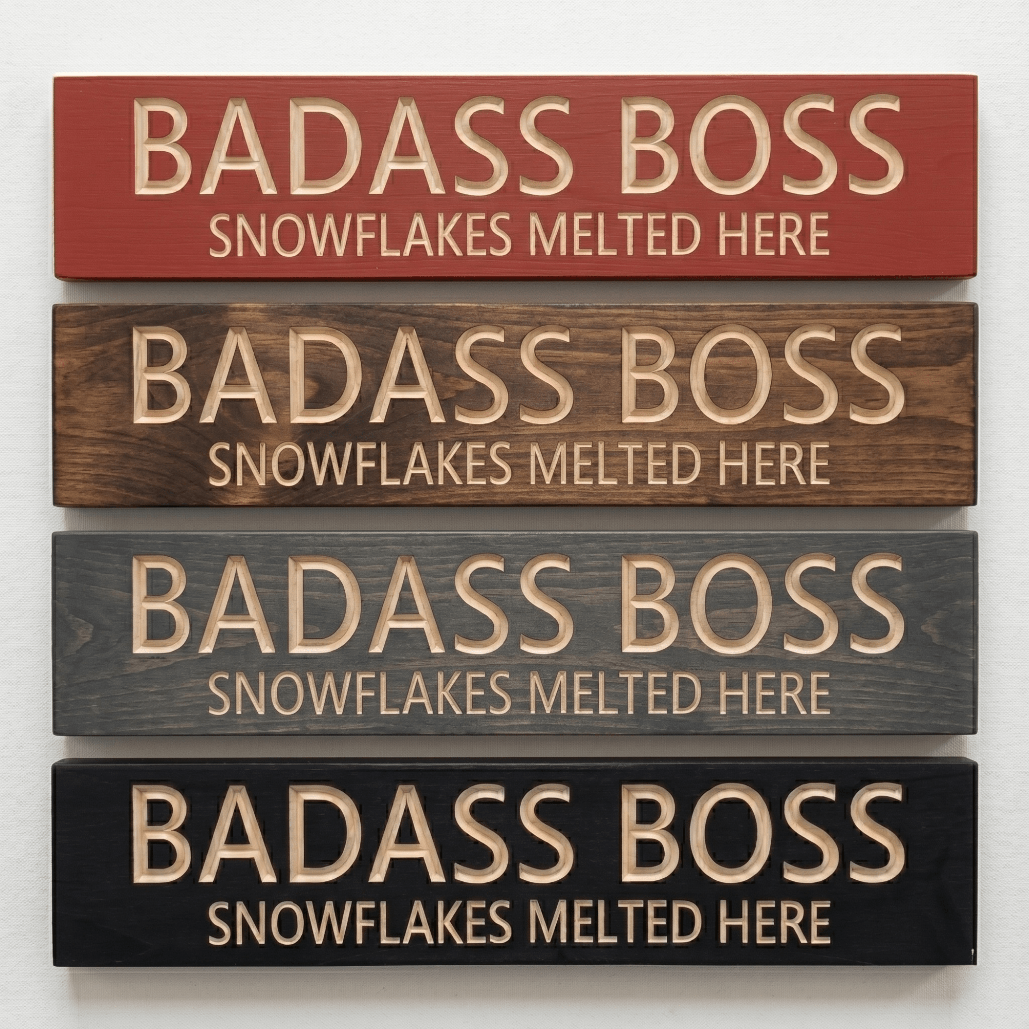 Four Badass Boss Snowflakes Melted Here signs in barn red, walnut, gray, and ebony finishes.