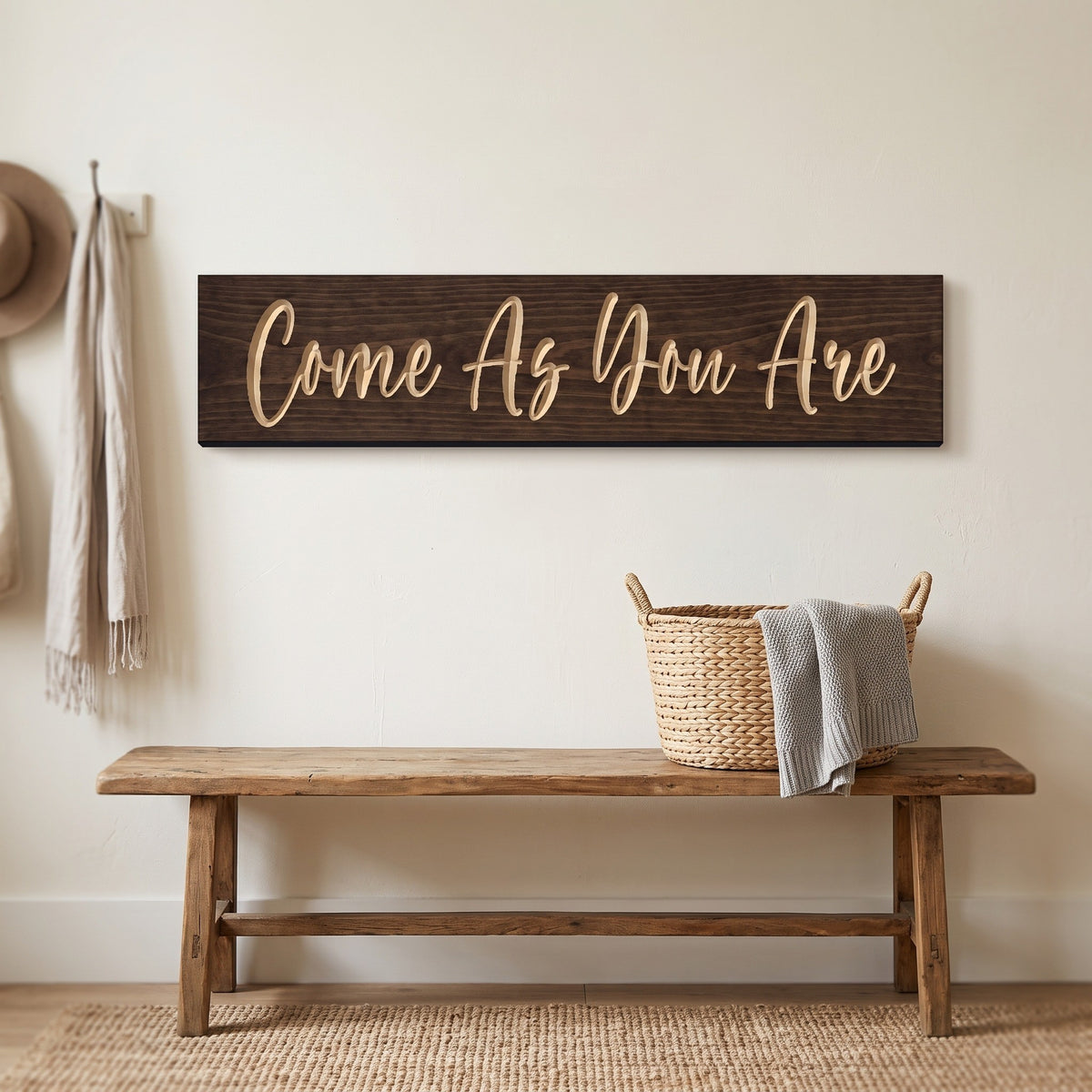 The Come As You Are sign hanging above a wooden entryway bench with a woven basket