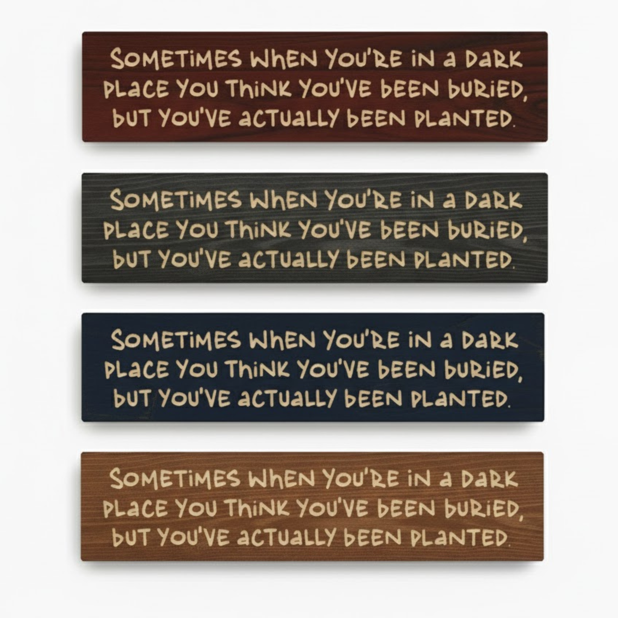 Four carved wood resilience signs displayed together to showcase the different handmade finish options available, including dark walnut, ebony, navy, and a lighter wood stain.