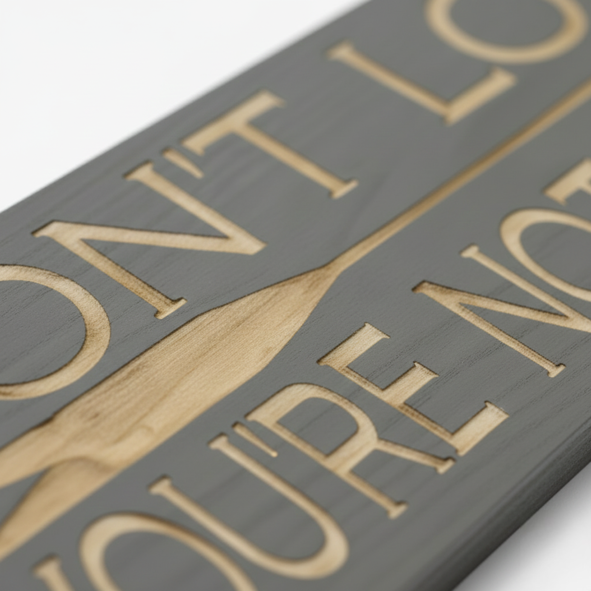Macro close-up of the "Don't Look Back" sign highlighting the deep CNC-carved arrow and text revealing the natural wood grain.