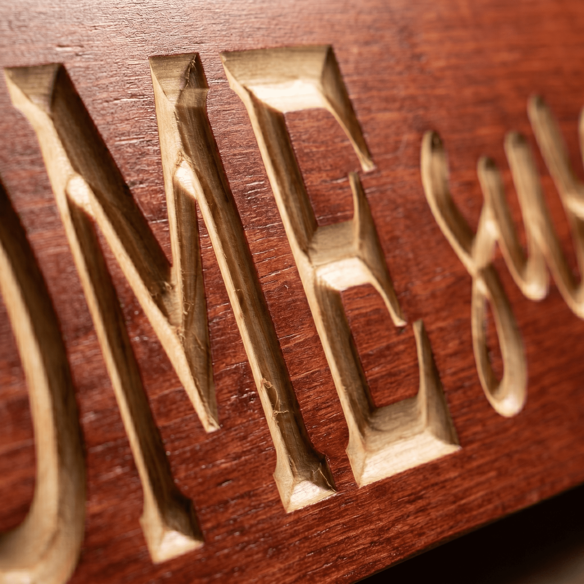 Macro close-up of CNC carved ME letters and script lettering on the Home Sweet Home wood sign revealing real pine grain, hand-finished depth, and authentic Kentucky craftsmanship.