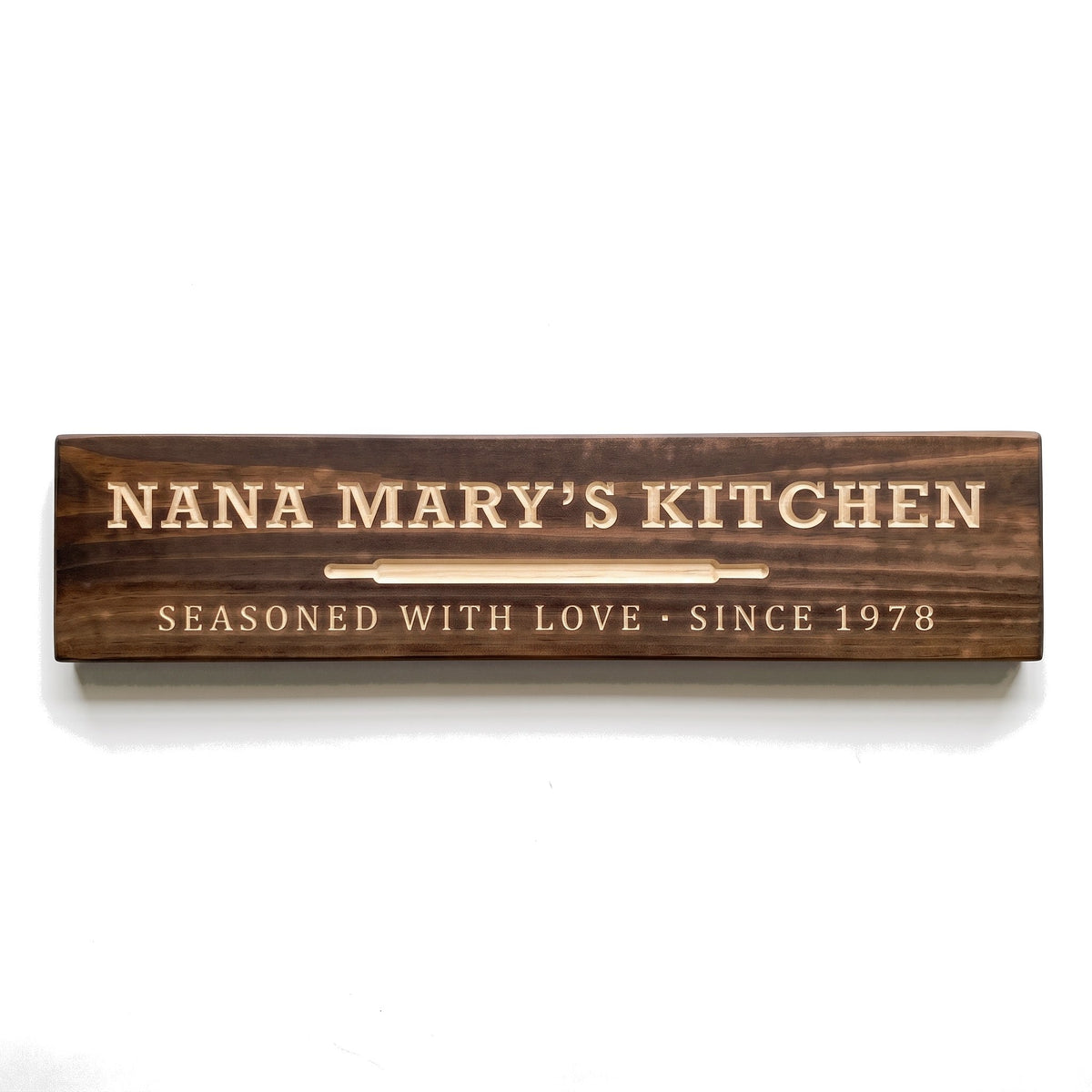 Personalized Nana Mary's Kitchen sign carved into solid wood in a Dark Walnut finish, straight on, on a white background (studio photo)