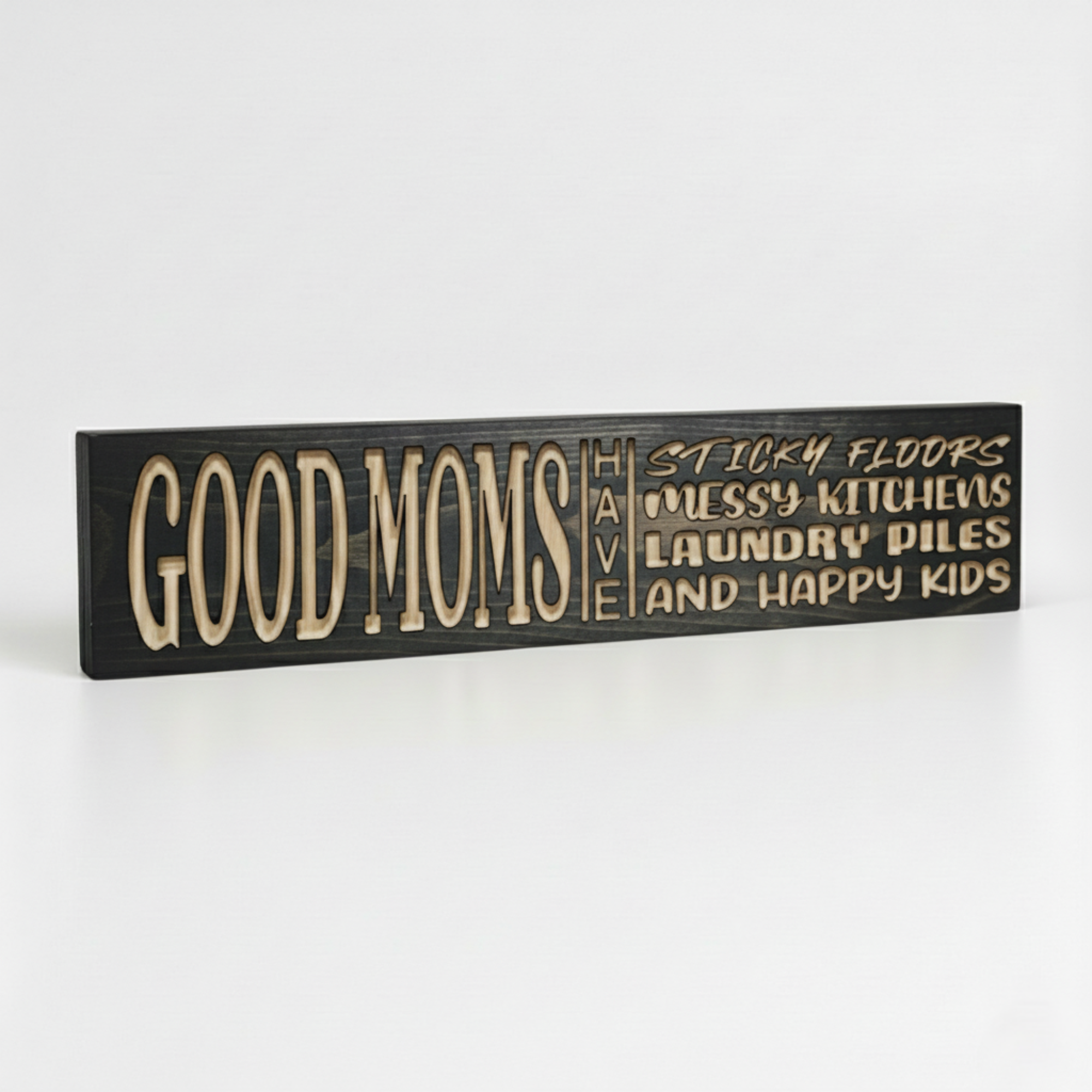 Perspective view of a handmade wooden wall sign for moms featuring deeply carved lettering and natural wood grain.