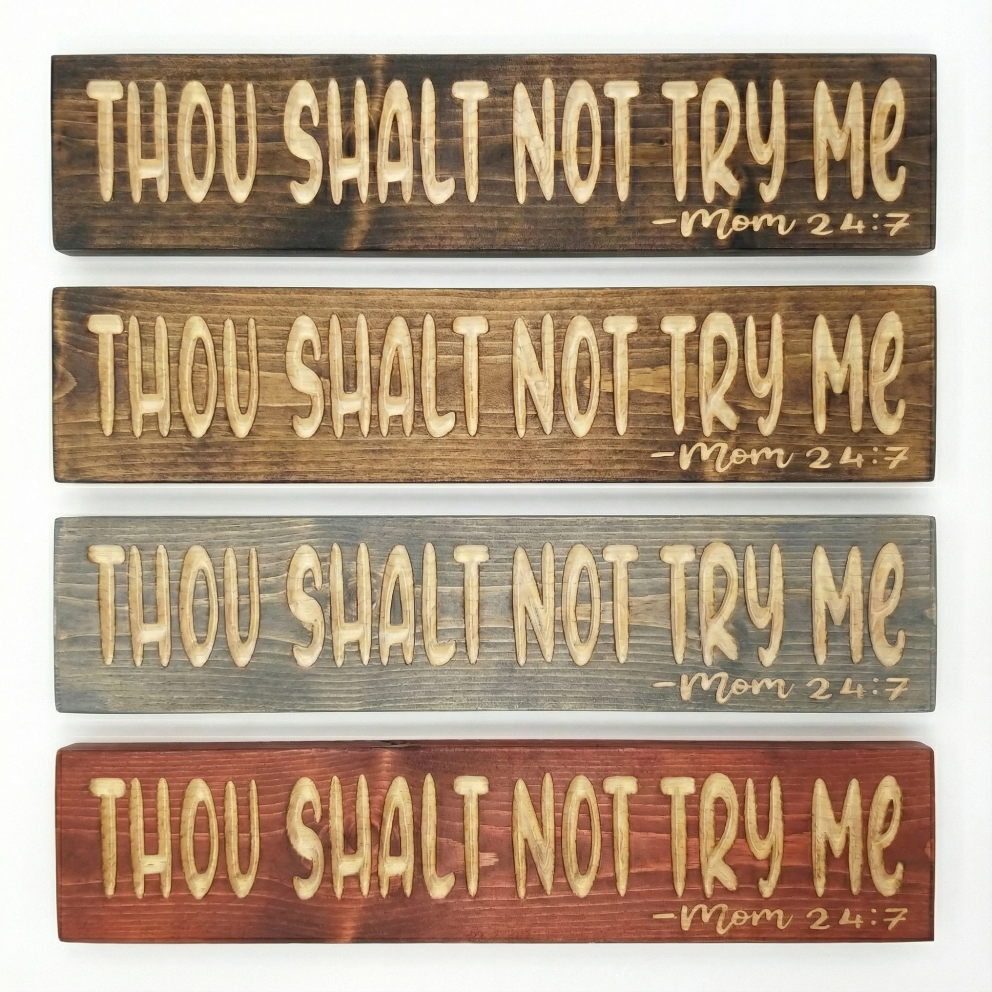 A stack of four Bluegrass Gifts "Thou Shalt Not Try Me" wooden signs showcasing different available stain color options.