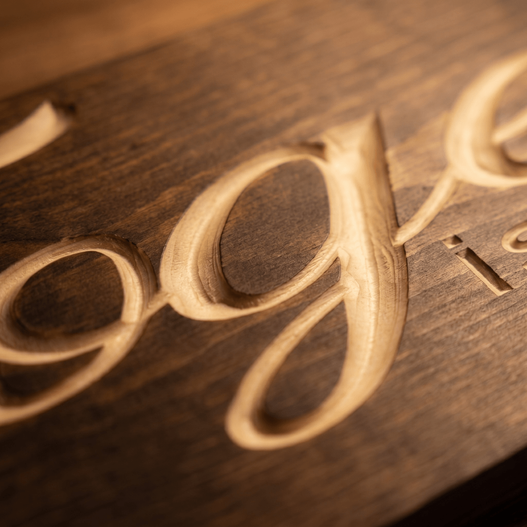 Macro close-up of the deep CNC-carved script letters on the Together is a Wonderful Place to Be solid wood sign showing natural pine grain and routed depth