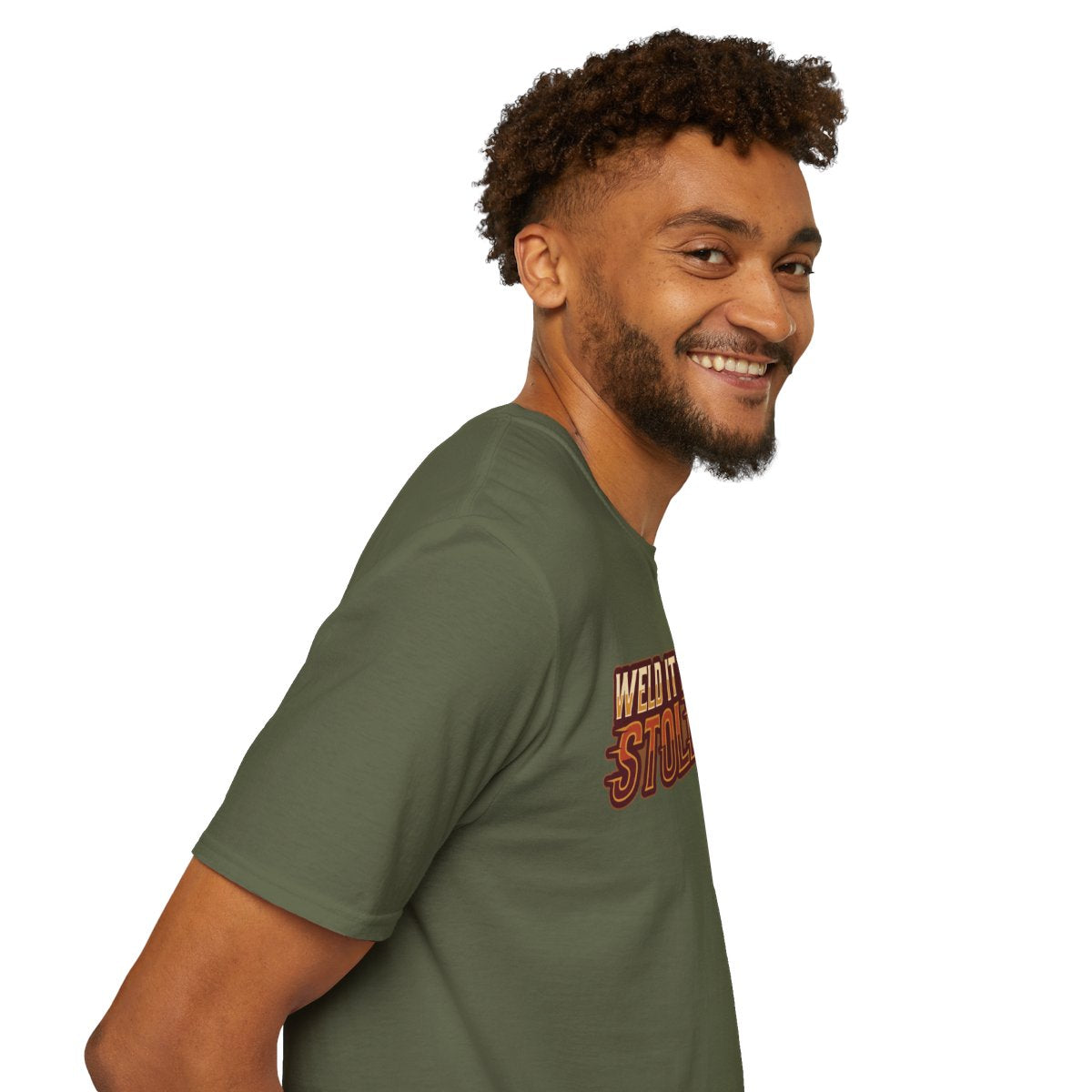 A man smiles, looking over his shoulder, wearing an olive green Welder Shirt - Weld It Like You Stole It, showing the graphic partially
