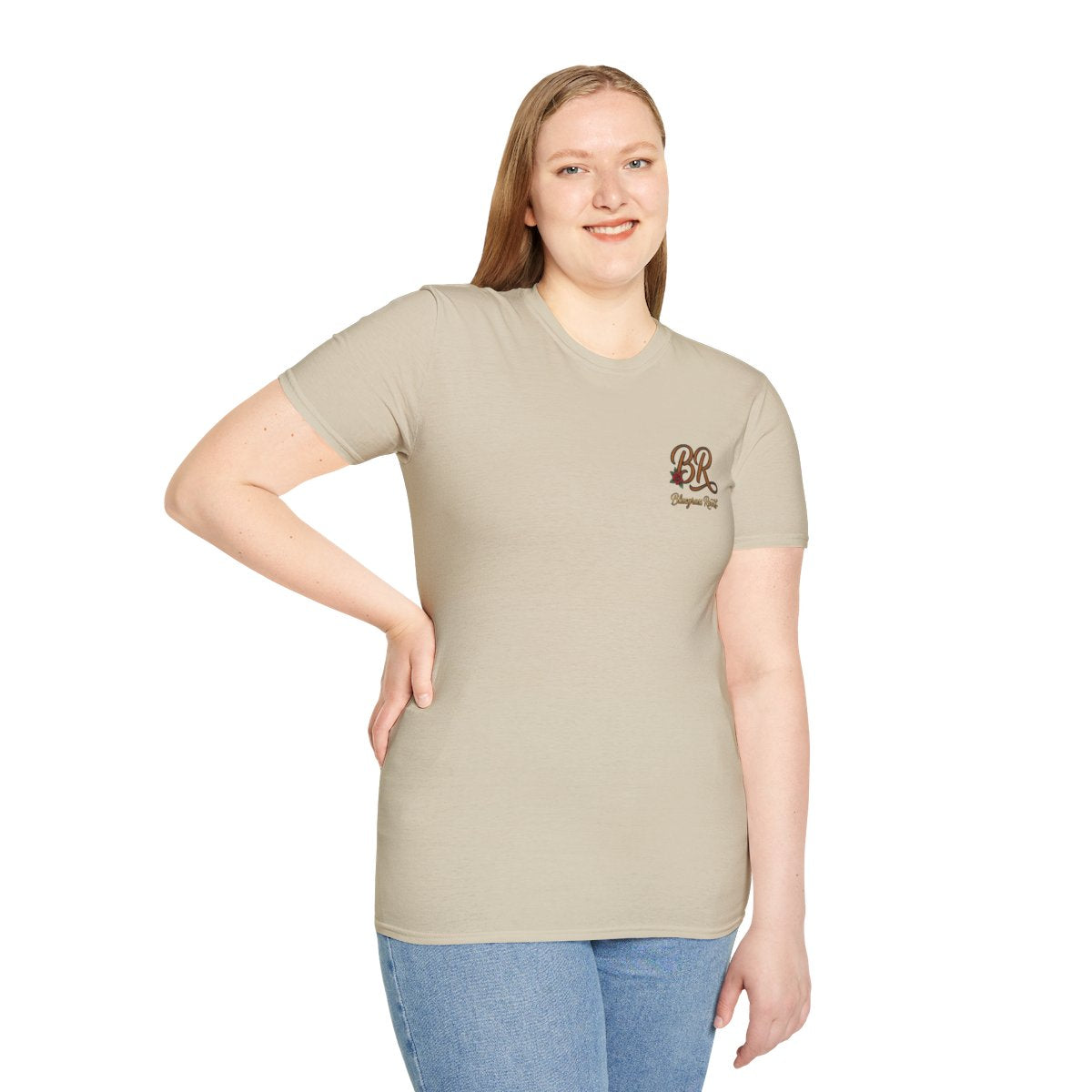 A woman smiles, looking forward, wearing a fitted beige Country Shirts Women tee with the front BR logo
