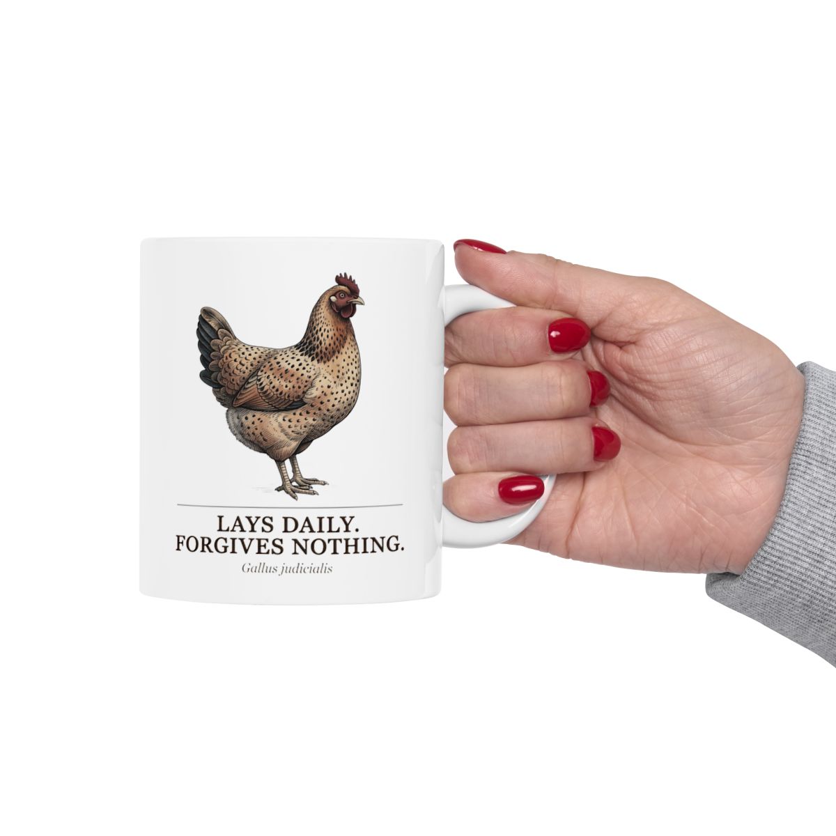 A hand with red nail polish firmly gripping the handle of a white Chicken Coffee Mug, against a plain backdrop