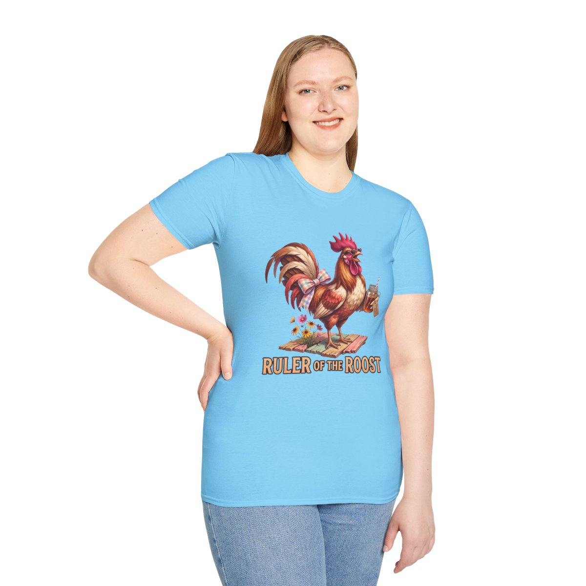 A smiling woman models the light blue "Rooster Shirt - Ruler of the Roost" tee, standing with one hand on her hip
