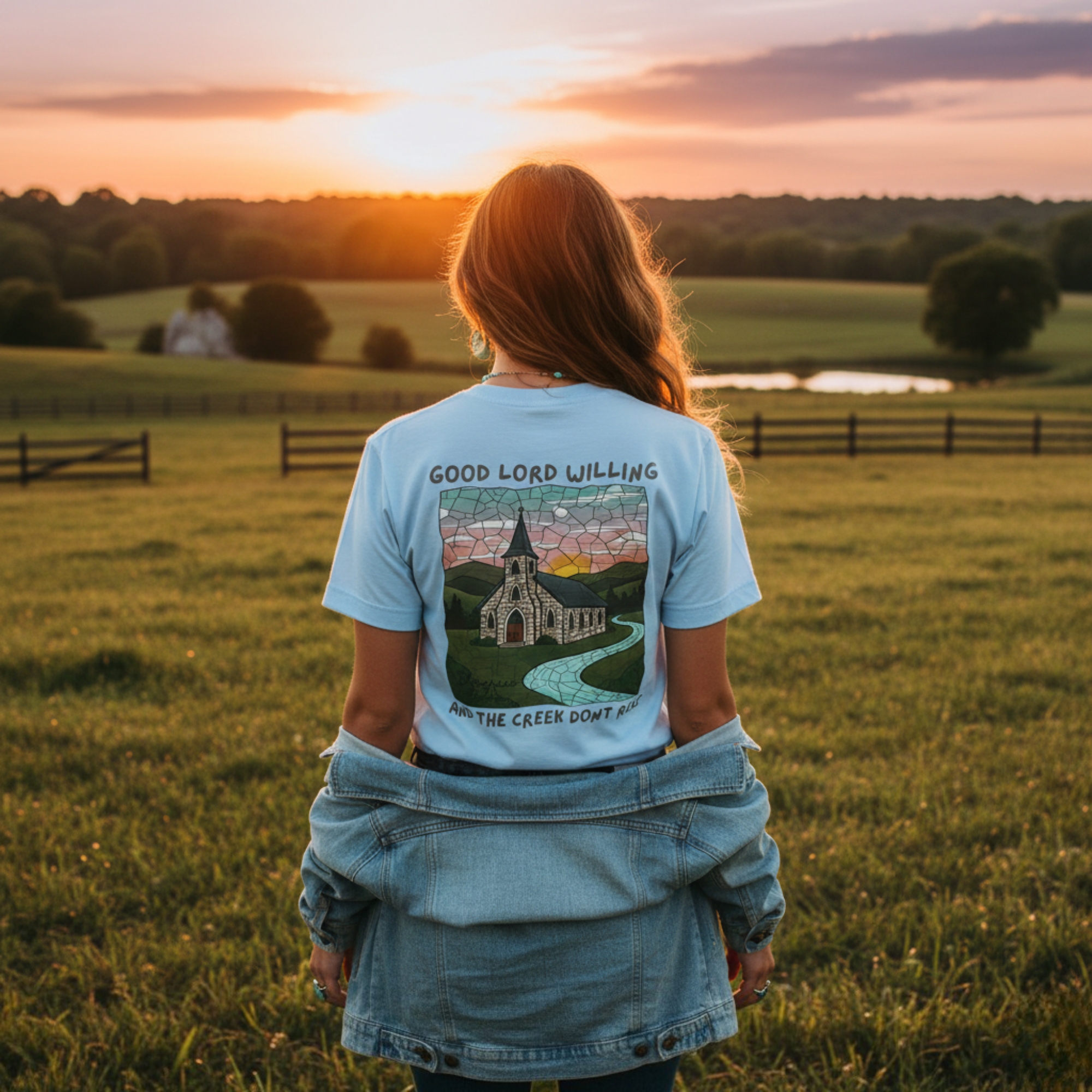 Back view of the 'Good Lord Willing and the Creek Don't Rise' t-shirt against a Kentucky sunset.