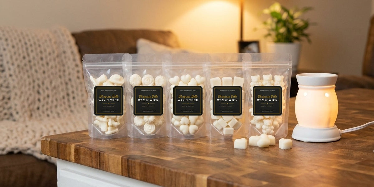Five bags of Bluegrass Belle wax melt tarts on a kitchen counter next to a glowing warmer
