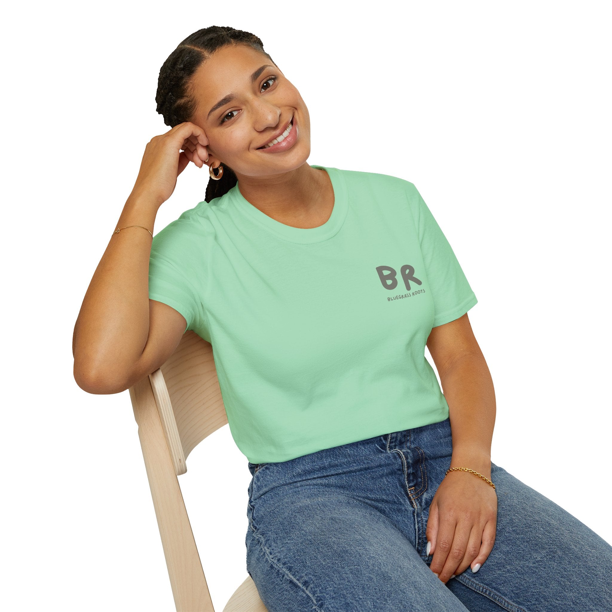 Woman wearing a light green t-shirt with 'BR' logo sitting on a chair.