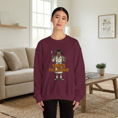 Person wearing a maroon sweatshirt with a graphic design in a living room.
