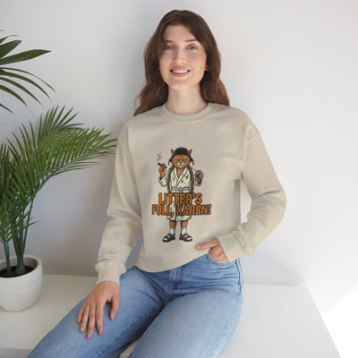 Person wearing a beige sweatshirt with a graphic design sitting on a white surface.