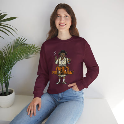 Person wearing a maroon sweatshirt with a graphic design and text, sitting on a white surface with a plant in the background.