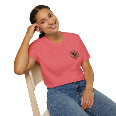 Woman wearing the Bluegrass Roots Prayed Up Laced Up Fed Up cowgirl boot tee in Coral Silk, casual lifestyle pose