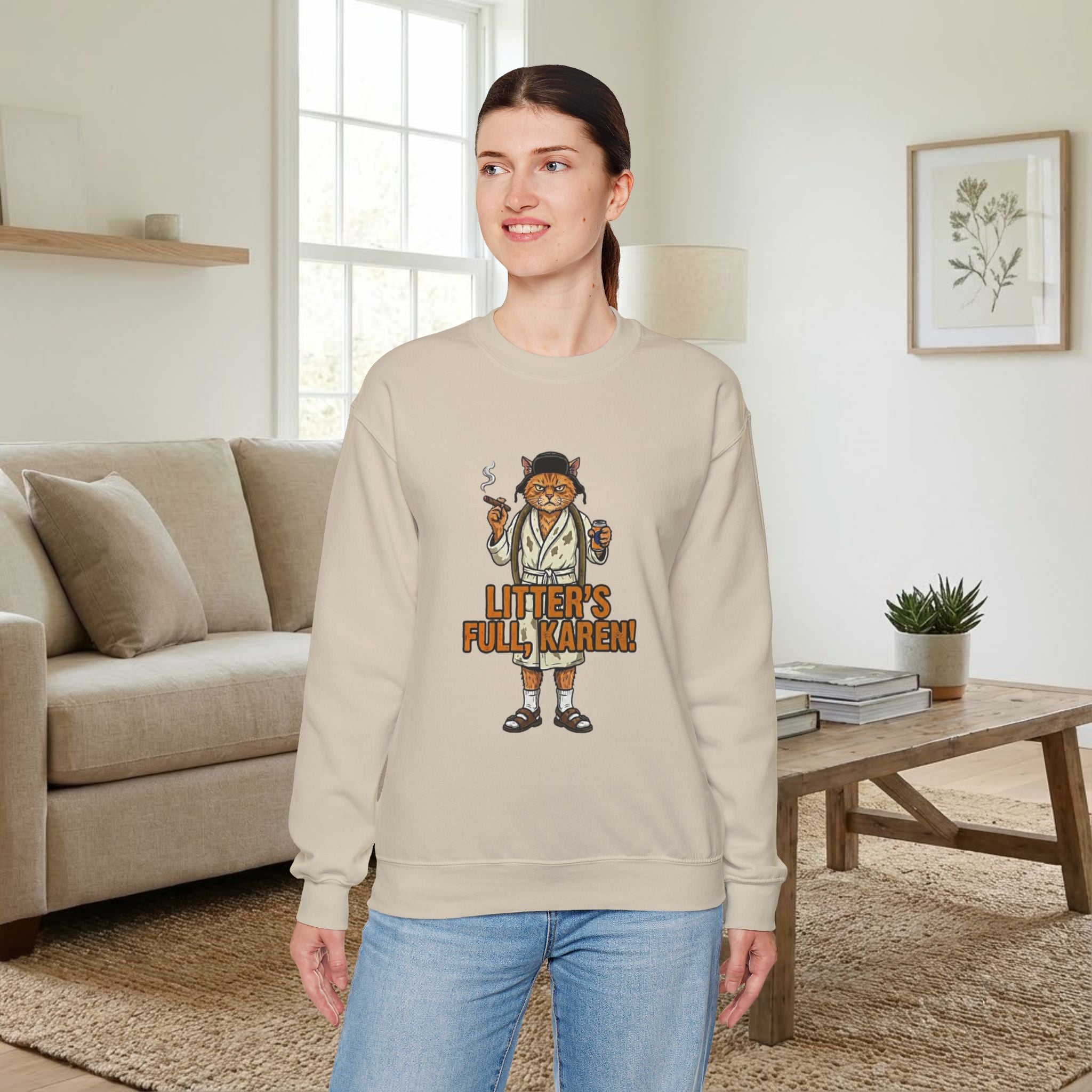 Woman wearing a beige sweatshirt with a graphic design in a living room.