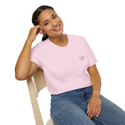 Woman wearing a pink t-shirt with a logo sitting on a chair against a white background