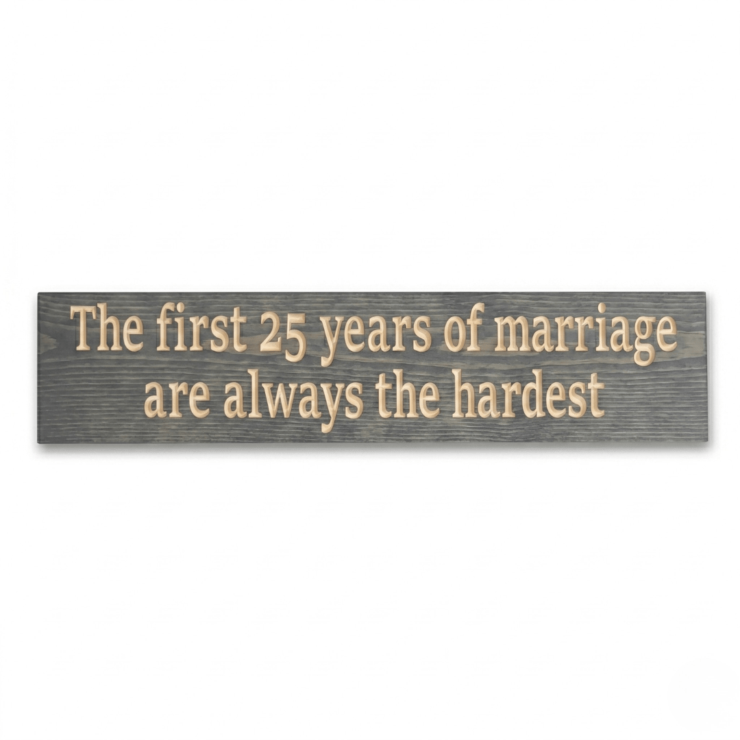 CNC-carved 25th anniversary wood sign in gray stain reading The first 25 years of marriage are always the hardest, flat lay on white background