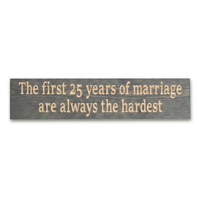 CNC-carved 25th anniversary wood sign in gray stain reading The first 25 years of marriage are always the hardest, flat lay on white background