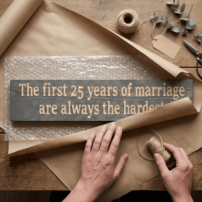 Handcrafted 25th anniversary wood sign being wrapped in kraft paper and bubble wrap as a ready-to-give anniversary gift