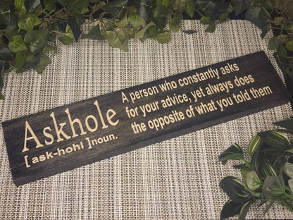 ASKHOLE funny definition wooden sign displayed on an office desk.
