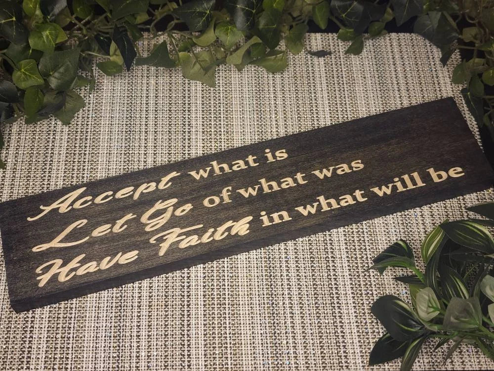 "Accept What Is, Let Go of What Was, Have Faith in What Will Be" wooden sign displayed in a cozy, serene bedroom.
