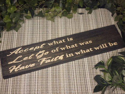 "Accept What Is, Let Go of What Was, Have Faith in What Will Be" wooden sign displayed in a cozy, serene bedroom.
