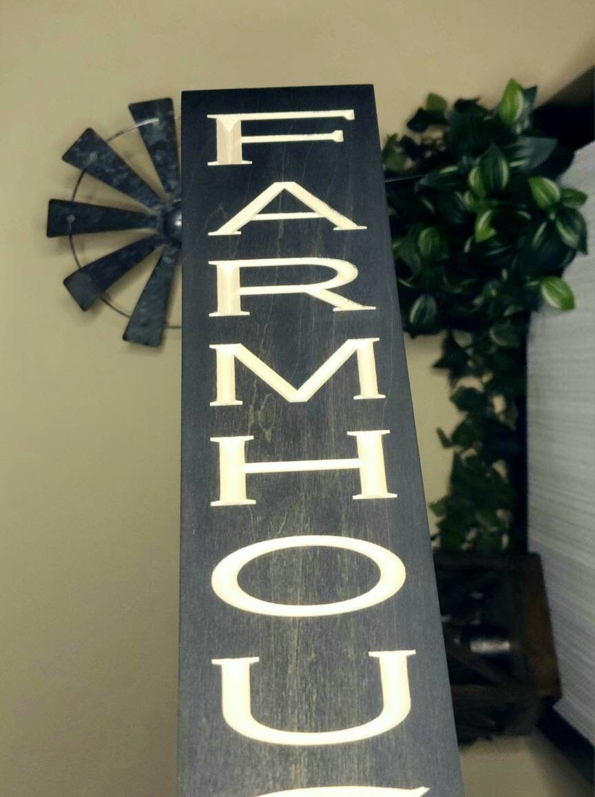 Bold "FARMHOUSE" wooden sign styled as part of a modern farmhouse home.
