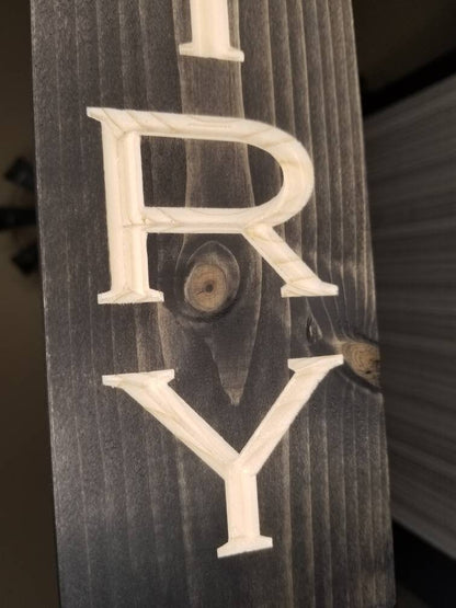 Decorative wooden pantry label sign used as functional kitchen wall art.
