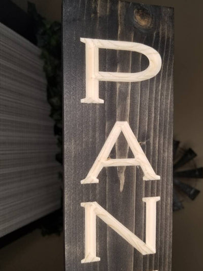 Farmhouse-style pantry sign adding charm to a rustic kitchen setup.
