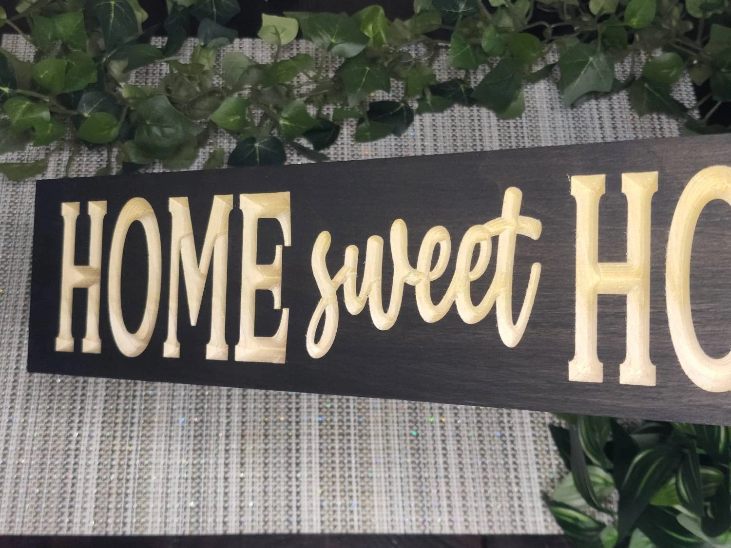 Farmhouse-style wooden Home Sweet Home sign in a modern kitchen.
