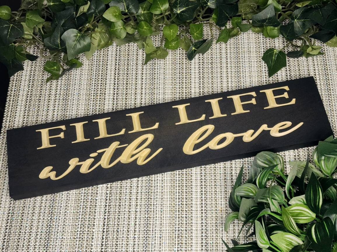 Fill Life with Love wooden sign styled in a cozy farmhouse living room.
