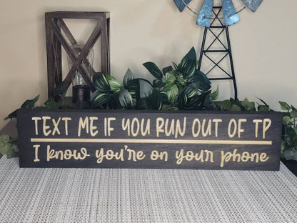 Funny bathroom wall art with a relatable quote styled on a powder room shelf.
