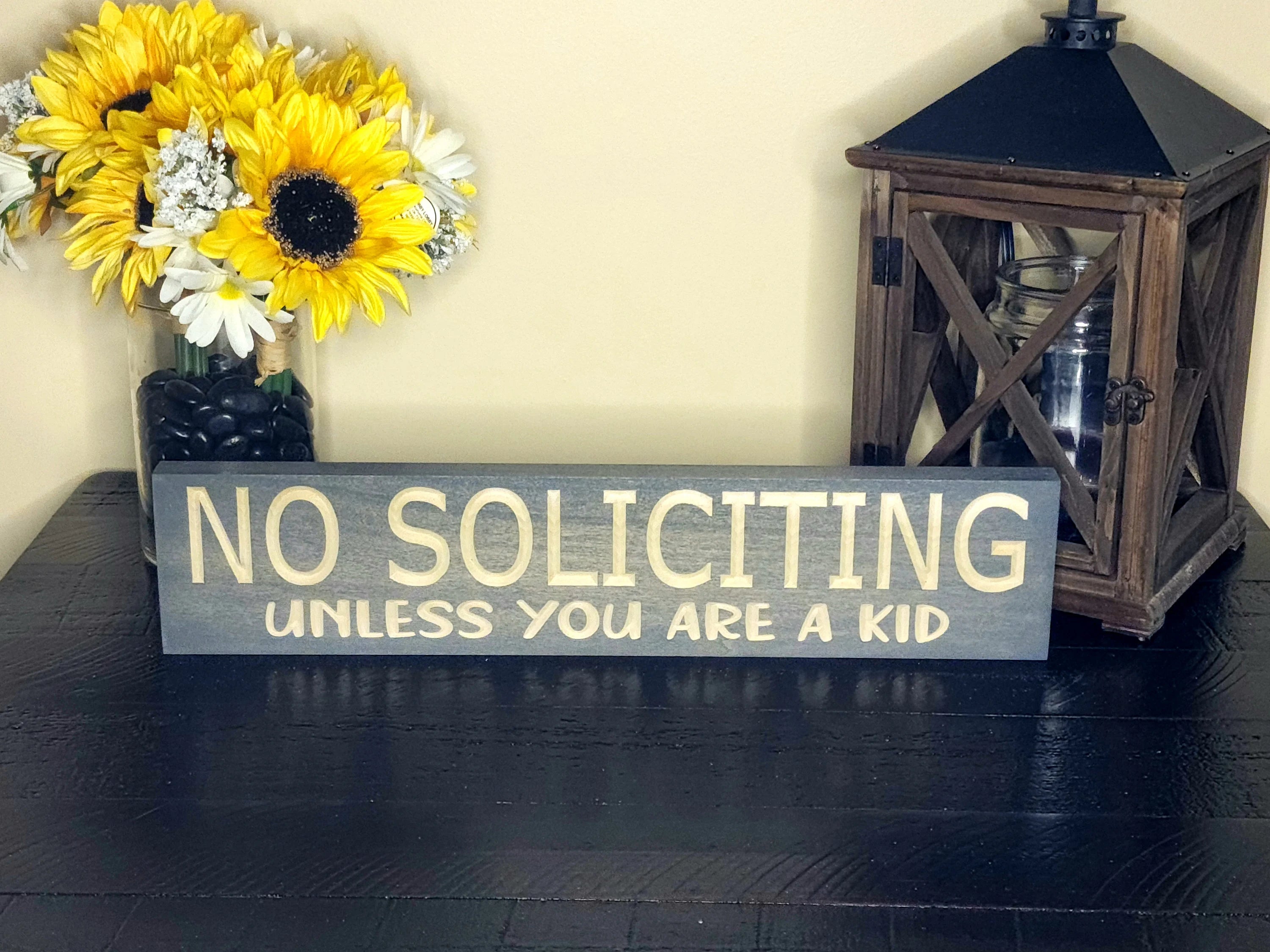 Funny no soliciting sign adding humor and charm to a cozy porch entryway.
