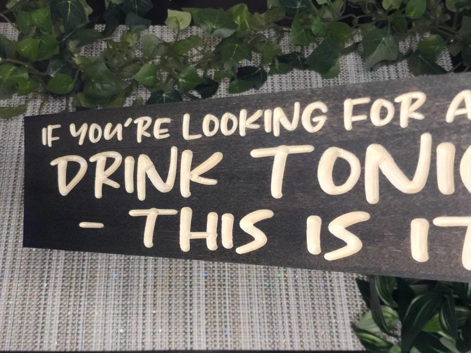 Humorous party host wall art with cheeky bar quote for happy hours.
