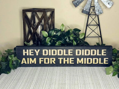 Humorous wall art for restroom with witty aim for the middle message