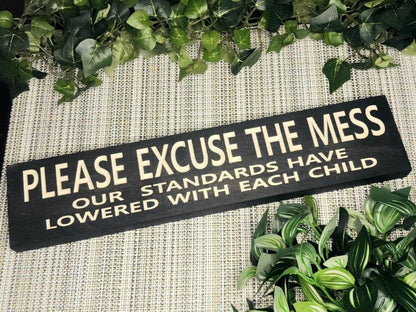Humorous wooden parenting sign displayed in a cozy family living room.
