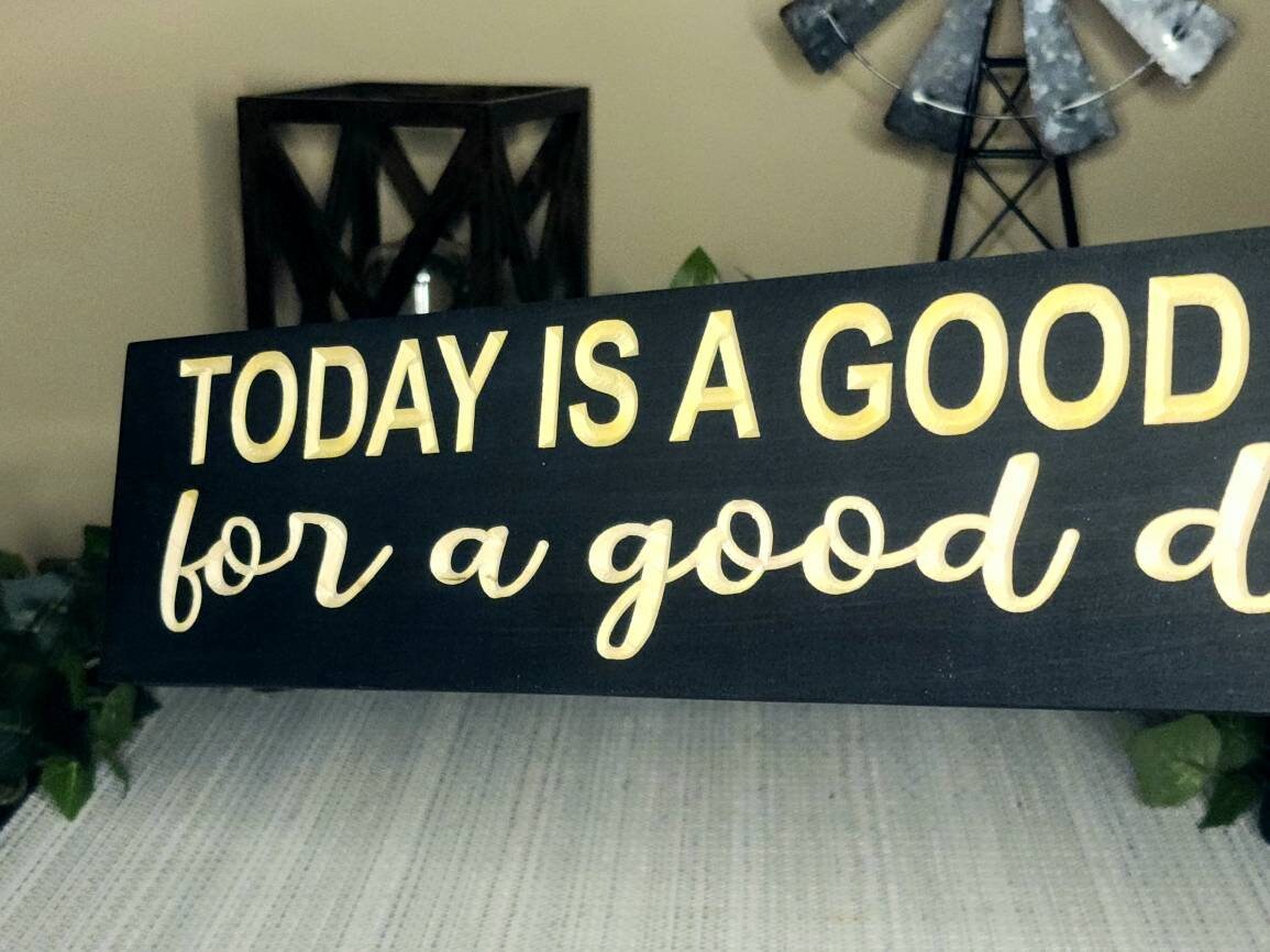 Inspirational wooden sign hanging in a farmhouse-style living room.
