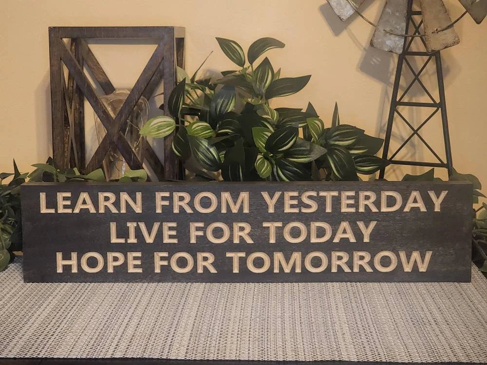 Inspirational wooden sign hanging in a modern home office for daily motivation.
