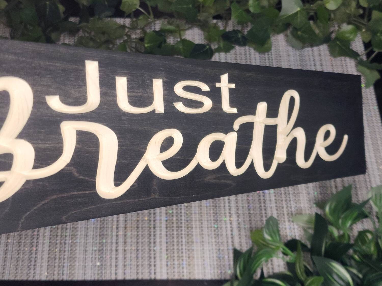 Just Breathe wooden wall décor styled in a modern meditation corner.
