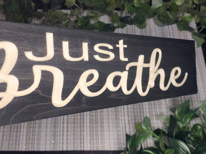Just Breathe wooden wall décor styled in a modern meditation corner.
