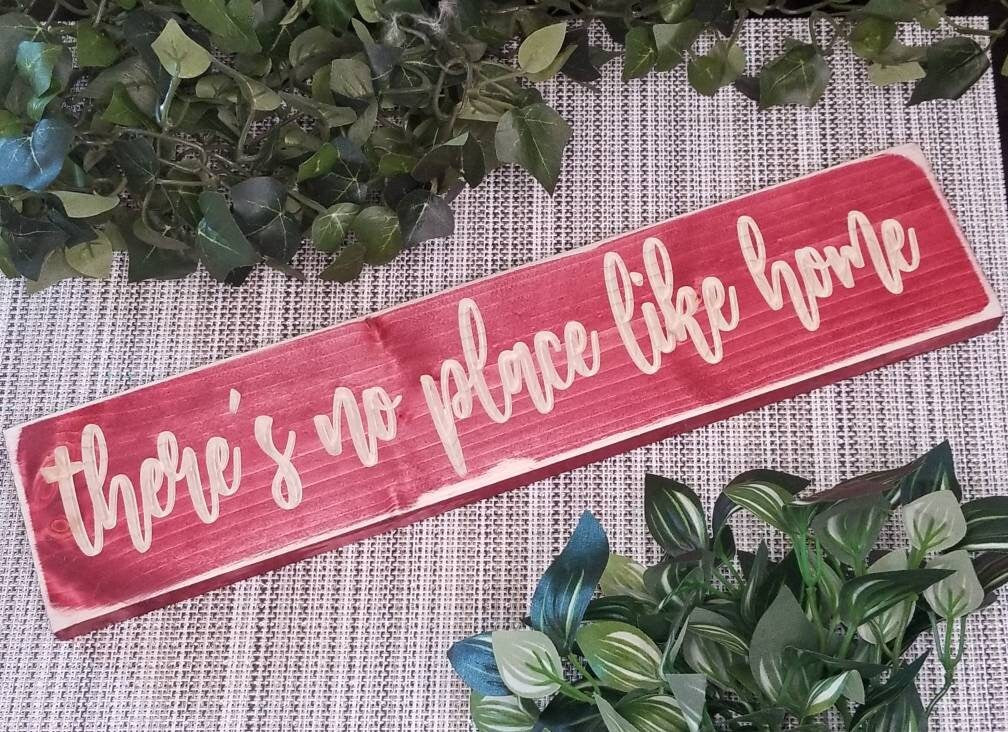 Personalized "No Place Like Home" sign styled on a mantel with warm accents.
